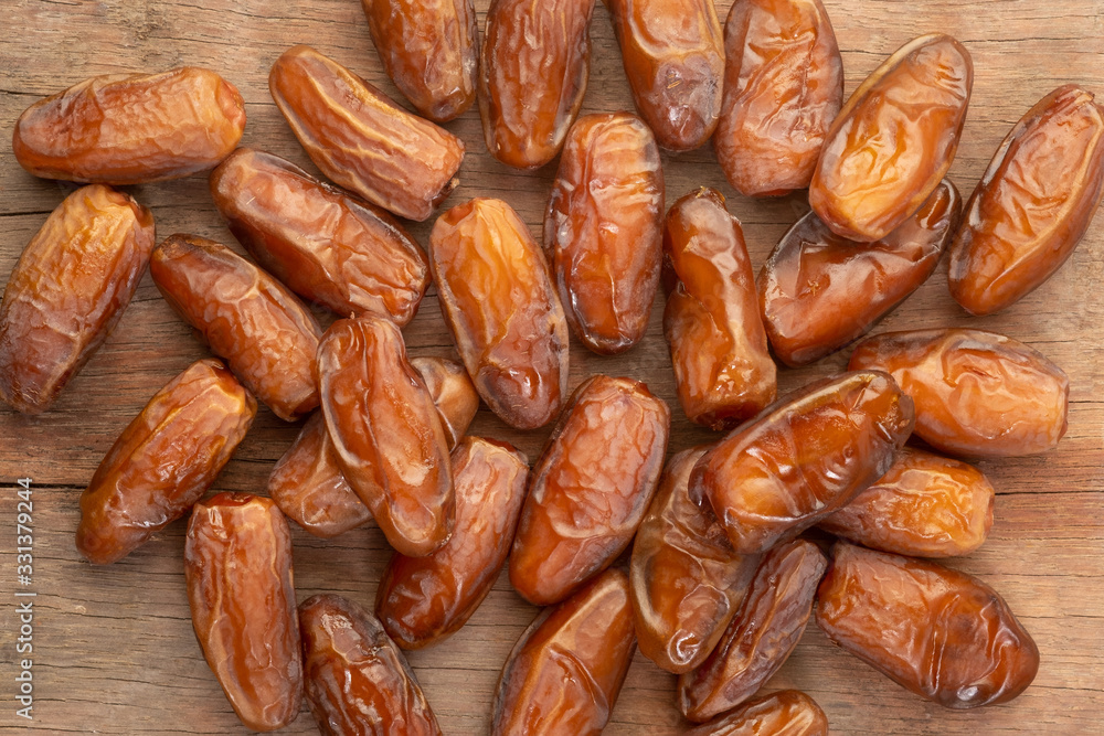 Close up of cluster dates plam. Fresh dates plam on wooden table. Close up of cluster dates plam. Fresh dates plam on wooden table.