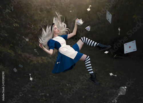 Fotografia, Obraz A beautiful blond girl is levitate with a mug of tea above the ground