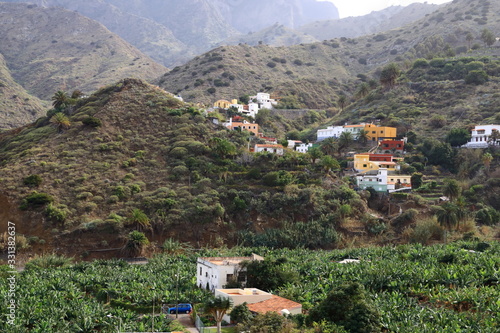 view to the village Hermigua on the Canary island La Gomera with multi colored houses and palm trees