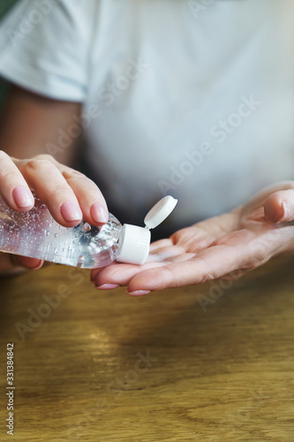 Woman in cafe treats hands with disinfectant antiseptic as prophylaxis the fight against coronavirus infection. The concept of personal hygiene in public places. Measures against the spread of virus
