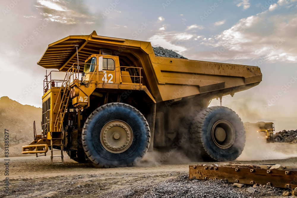 Obraz premium Mining dump trucks transporting Platinum ore for processing