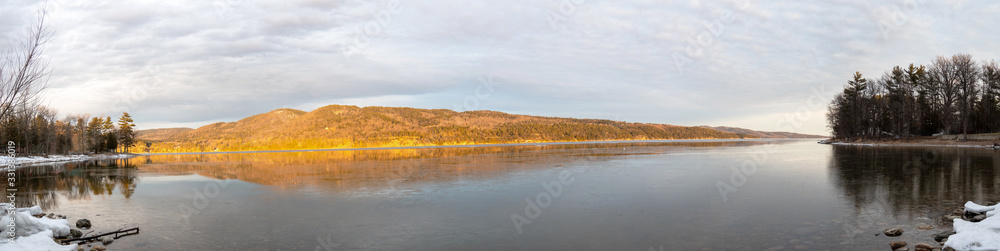 Panoramic view of a lake and mountains at winter sunrise