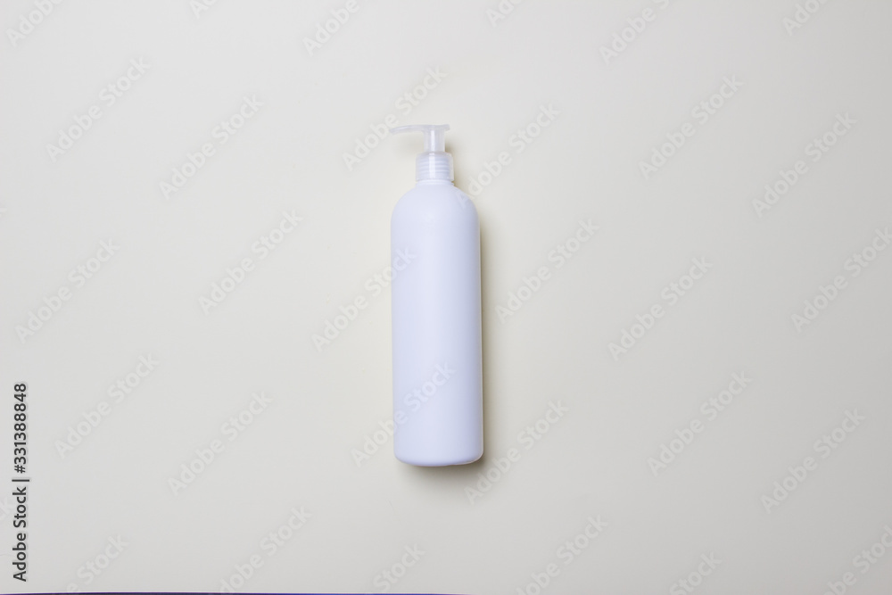 white bottle with detegrent on colored paper background white bottle with detegrent on colored paper background