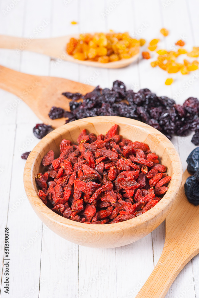 dried goji, cherry, raisin and plum fruits on white wood dried goji, cherry, raisin and plum fruits on white wood