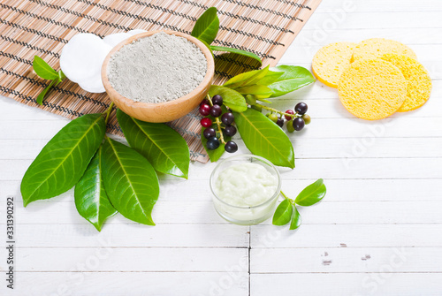 cosmetic clay in bamboo bowl and face cream