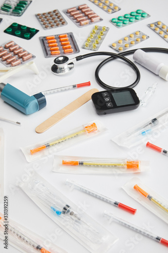 High angle view of colorful medicines, syringes and medical objects on white