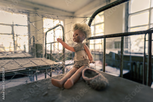 Fototapeta Naklejka Na Ścianę i Meble -  Dusty toy puppet sitting on bunk bed in abandoned kindergarden in Chernobyl Exclusion Zone