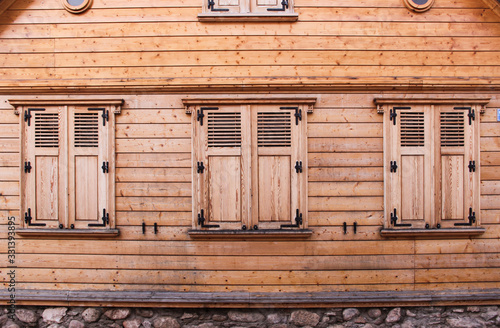 The traditional wooden facade of an Old Town building in Latvia. Wooden house facade with closed shutters. 