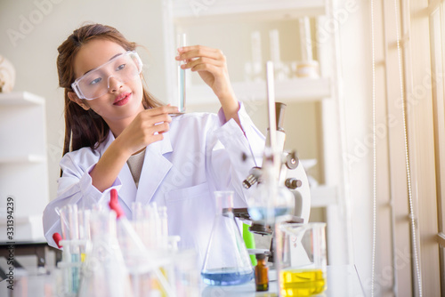 Attractive happiness Scientist woman using microscope testing some blood sample at laboratory with lab glassware on the table. Science or medical research and development new antivirus concept.