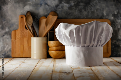 White cook hat on desk and kitchen interior 