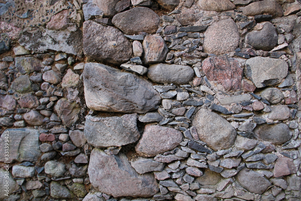 Old wall made of rocks. Medieval surface made of bricks. Texture of an old rocks sticked up with a cement. Old wall made of rocks. Medieval surface made of bricks. Texture of an old rocks sticked up with a cement.