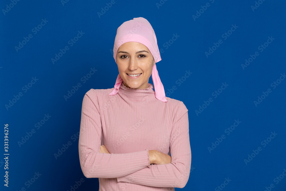 Young woman with pink scarf on the head on a blue background Young woman with pink scarf on the head on a blue background