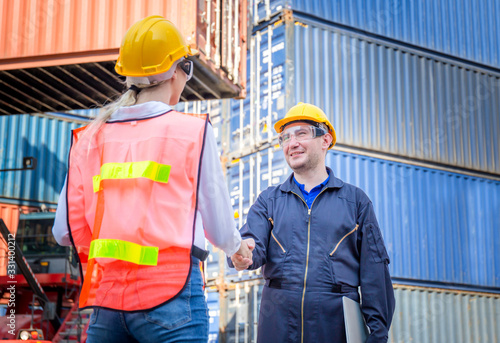 Engineer and worker handshake with blurred containers cargo background, Success and Teamwork concept