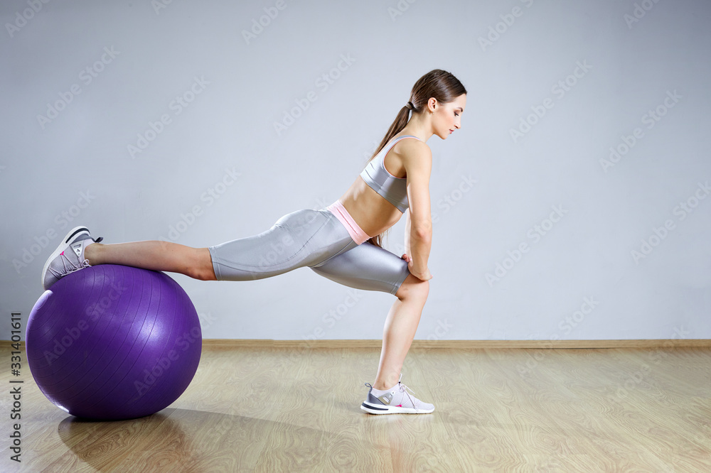 Young fit woman exercising in a gym. Sports girl is training cross fitness with Pilates Balls. Young fit woman exercising in a gym. Sports girl is training cross fitness with Pilates Balls.