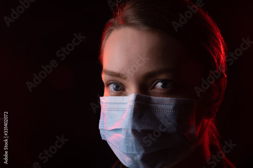 A girl in a protective mask from the virus of the coronavirus. Mass epidemic, pandemic in the USA, the European Union, Italy and Spain. Quarantine. Mourning. Photo for news and media. With space