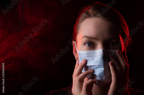 Coronavirus, girl in a mask on a black background. The title is about an outbreak of a coronavirus virus in the United States, Europe, Italy and Spain. epidemic. Photo for media headlines, news photo