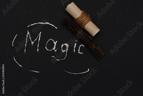 a bunch of decorative twigs and a scroll of paper on the background with the inscription magic