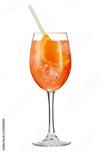 Aperol Spritz cocktail with a slice of orange, ice cubes and a green straw is contained in a high glass on the long stem. The bright illustrative picture is made on the white background.