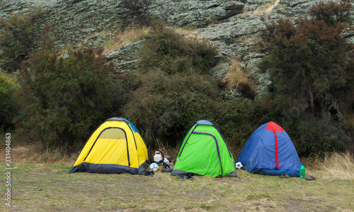 Tourists camped on a grass.Camping concept. Camping tents placedin the mountains.Tourist tent and equipment in the camp. Travel and Relax. Active lifestyle © renatados