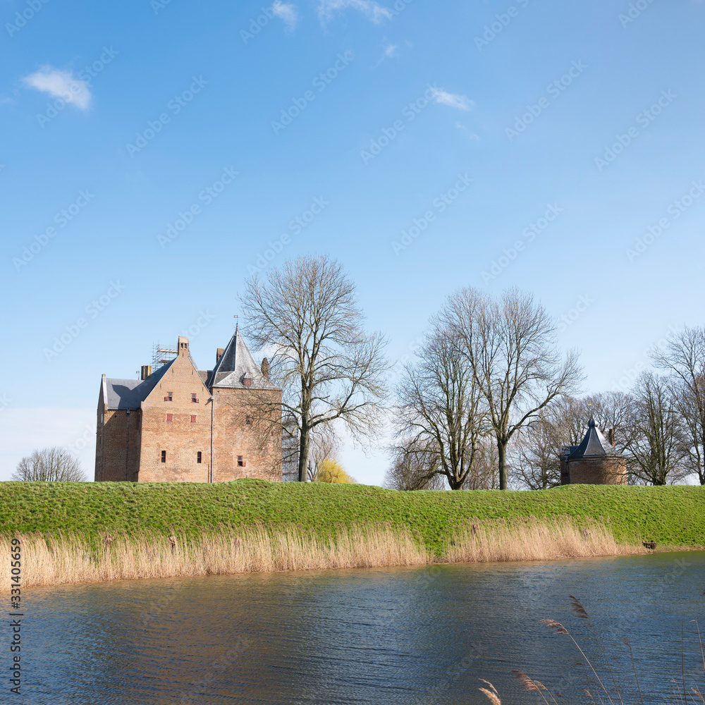 Obraz premium castle loevestein and moat under blue sky in the netherlands near river waal
