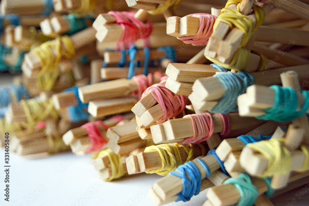 Many student's Chinese sticks with multi-colored rubber bands.