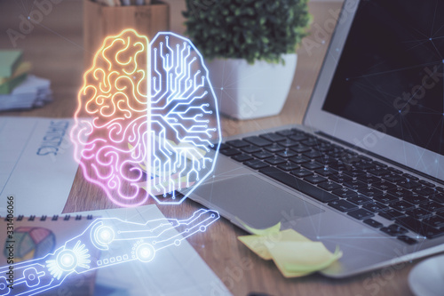 Double exposure of table with computer and brain hologram. Data innovation concept.