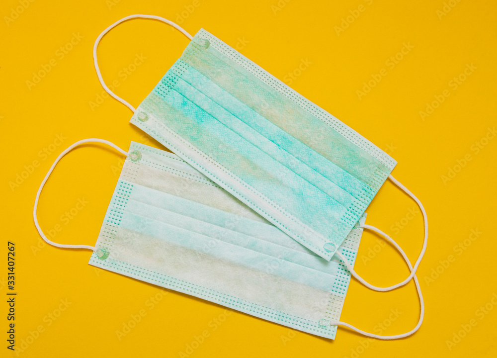 Two surgical masks on a yellow background. Coronavirus Prevention. Chinese coronavirus outbreak. Two surgical masks on a yellow background. Coronavirus Prevention. Chinese coronavirus outbreak.