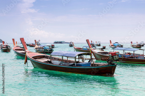Thai traditional wooden long-tail boat and beautiful sand beach. Longtail boat on tropical island in Thailand. Tropical beach, longtail boats, Andaman Sea. © Avirut S.