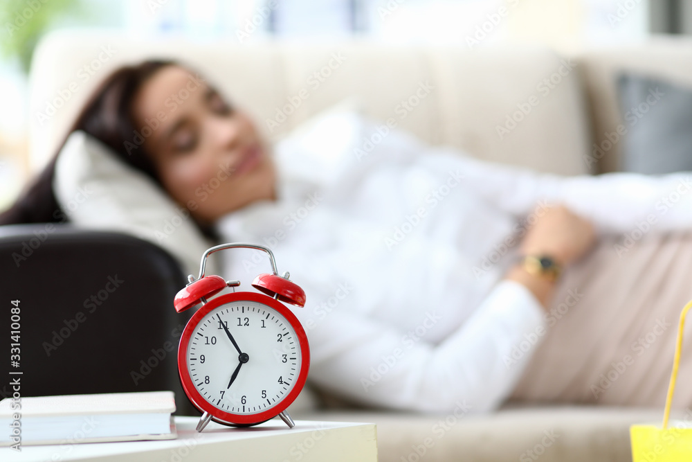 Girl is tired and lies on table an alarm clock. Woman is tired spending lot time shopping. Female shopping escort. On table is an alarm clock, woman is sleeping in clothes on couch Girl is tired and lies on table an alarm clock. Woman is tired spending lot time shopping. Female shopping escort. On table is an alarm clock, woman is sleeping in clothes on couch