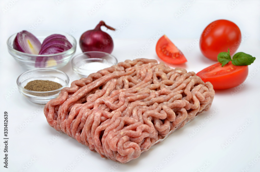 raw minced meat and vegetables on a white background raw minced meat and vegetables on a white background