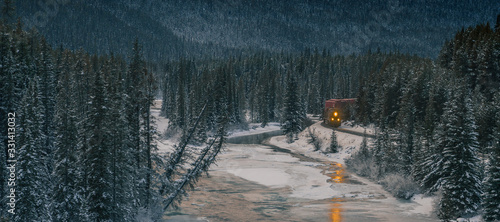 Photography Freight train with containers on picturesque Morant's curve on a cold winter evening with sun just setting behind majestic mountains