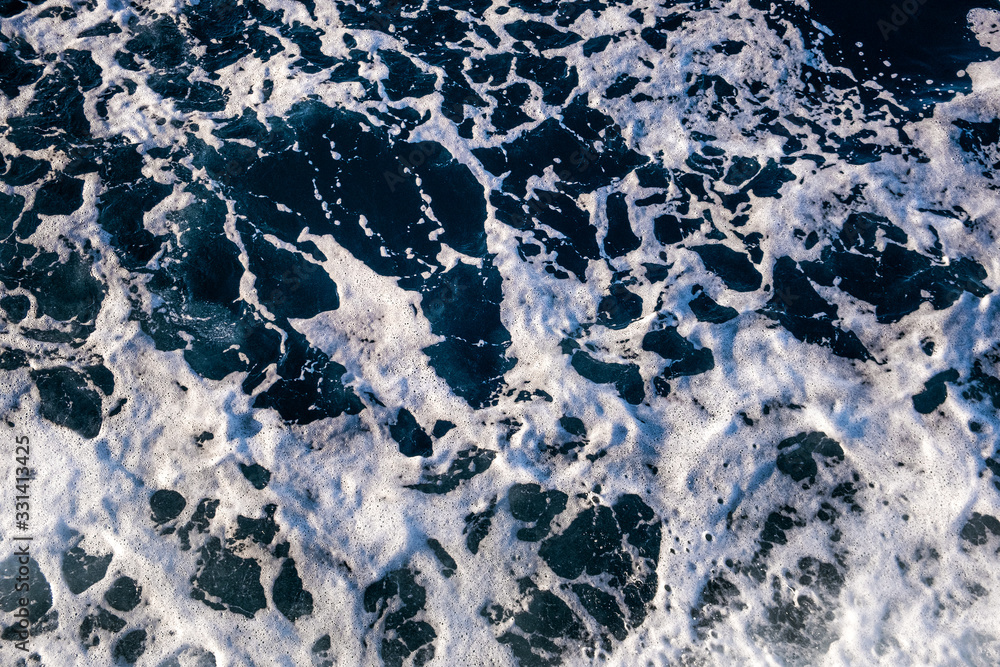 Obraz premium Top down aerial view of sea water surface. White foam waves texture as natural background.
