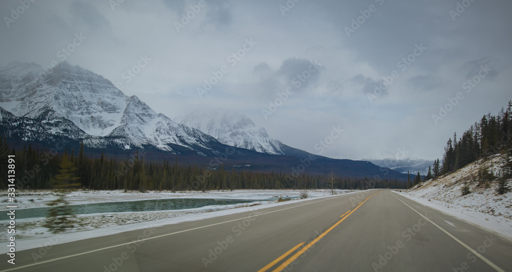 Panoramic photo of an asphalt road in canadian wilderness on a cold late autumn day. Roadtrip through canada.