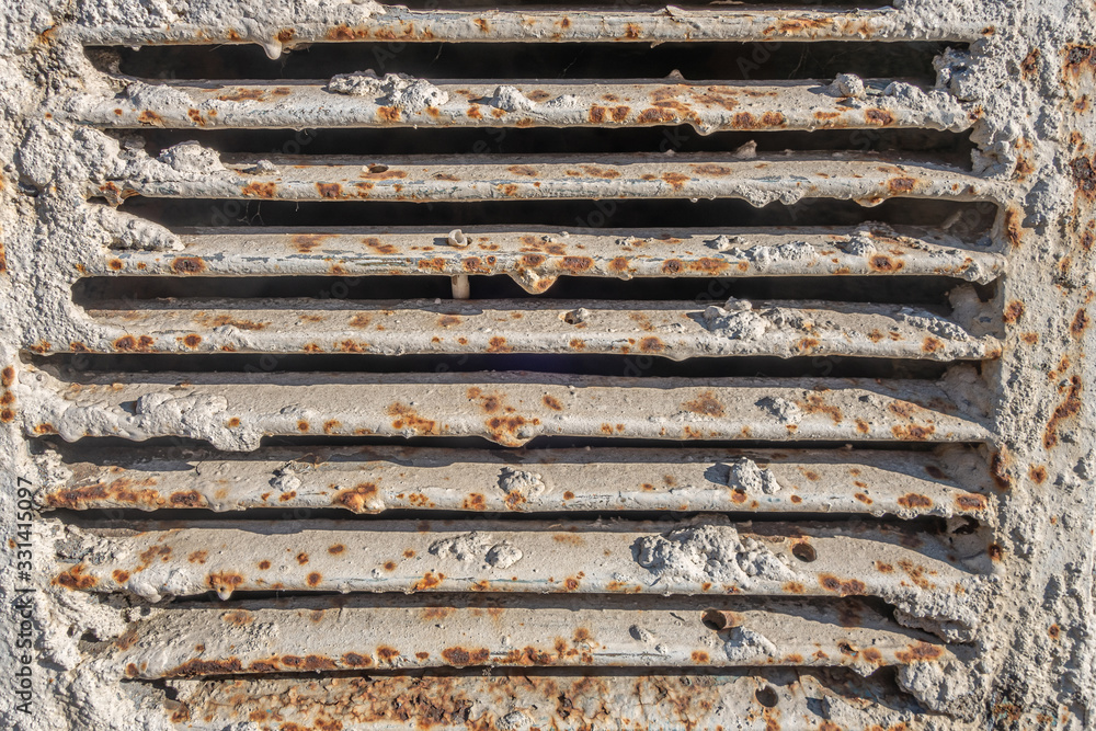 abstract background of an old ventilation grill in spots of rust close up