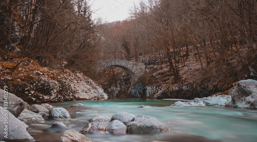 Beautiful stone bridge on Nadige river in enchanted forest photo