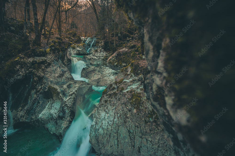 Beautiful water cascades or small waterfall in the valley of Lepena in Slovenian Julian Alps. Emerald green waterfalls in an enchanted forest.