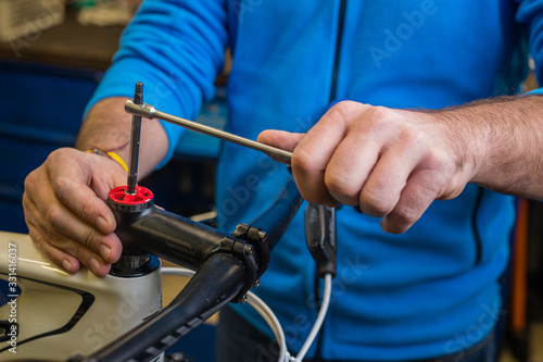 Tightening of a bicycle handlebar stem with the use of a small inbus wrench.