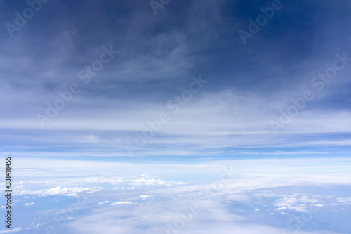 Skyscape view from clear glass window seat from aircraft to cloudscape, traveling on white fluffy clouds and vivid blue sky in a suny day