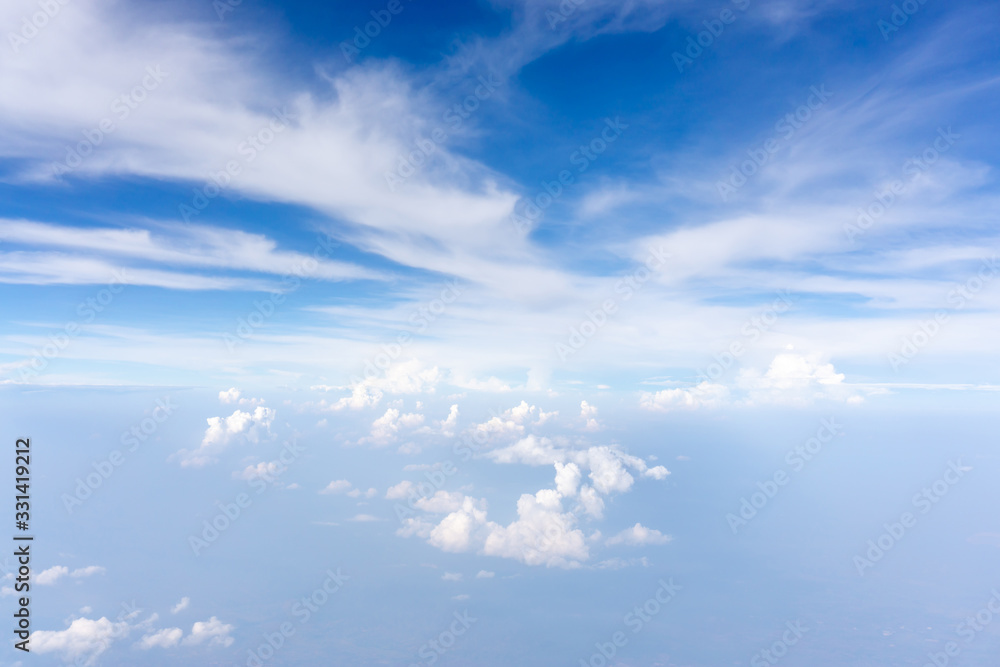 Skyscape view from clear glass window seat from aircraft to cloudscape, traveling on white fluffy clouds and vivid blue sky in a suny day