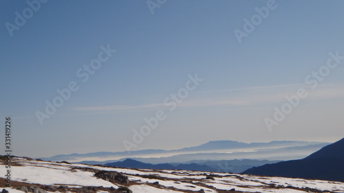 Montañas nevadas con horizonte y cielo azul