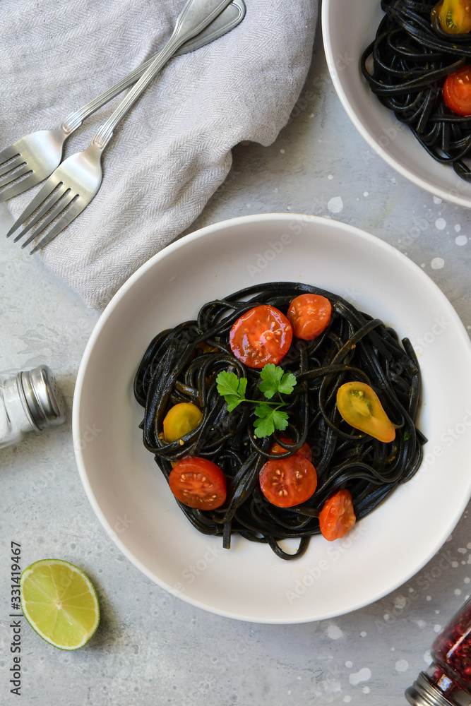 black spaghetti pasta with tomato sauce on white plates pasta recipe. Restaurant food delivery lunch at home. food delivery to quarantine COVID-19. black spaghetti pasta with tomato sauce on white plates pasta recipe. Restaurant food delivery lunch at home. food delivery to quarantine COVID-19.