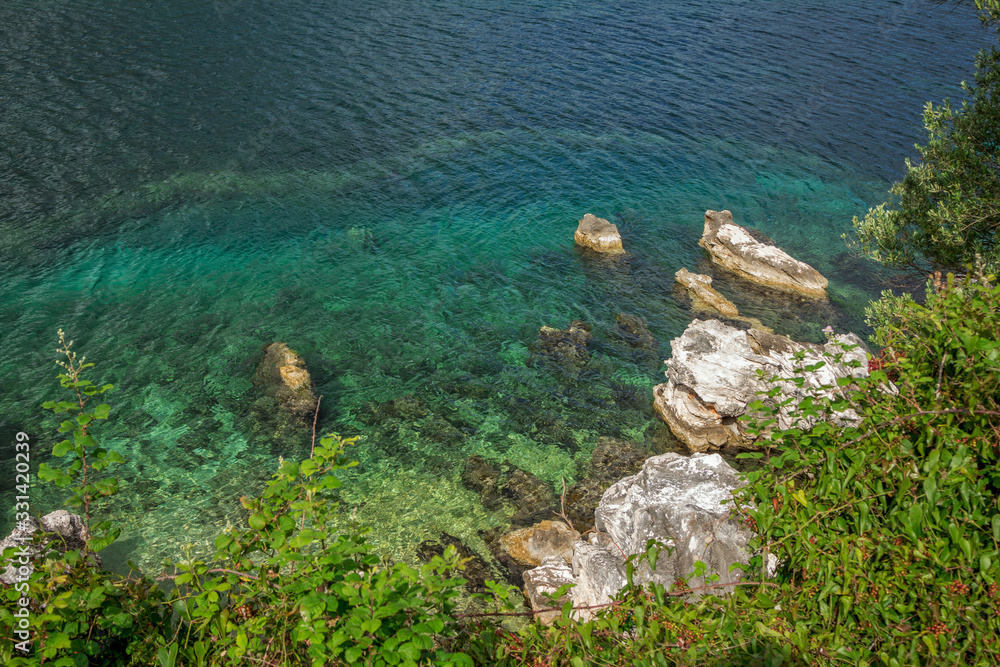 Beautiful landscape with sea bay with turquoise water, white rocks and cliffs on the shore, green trees and bushes. Corfu Island, Greece. Beautiful landscape with sea bay with turquoise water, white rocks and cliffs on the shore, green trees and bushes. Corfu Island, Greece.