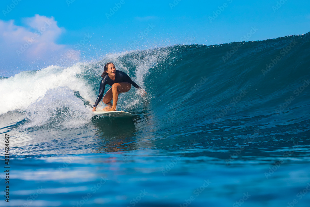 Female surfer on a blue wave