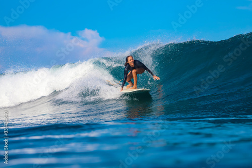 Female surfer on a blue wave