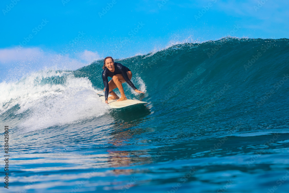 Female surfer on a blue wave Female surfer on a blue wave