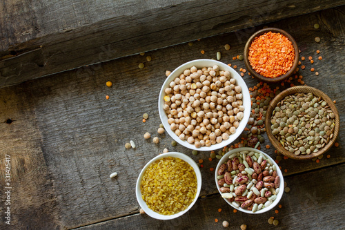 Diet and healthy eating concept, vegan protein source. Raw of legumes (chickpeas, red lentils, canadian lentils, beans, bulgur). Top view on a flat lay. Copy space.