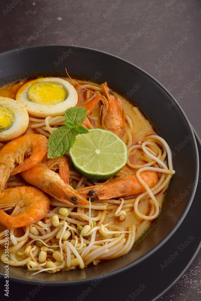 Laksa noodle soup with prawn, egg and bean sprouts garnish with lime and mint Laksa noodle soup with prawn, egg and bean sprouts garnish with lime and mint