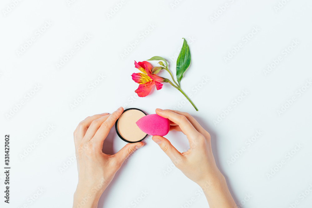 Makeup foundation and sponge blender in woman's hands Makeup foundation and sponge blender in woman's hands