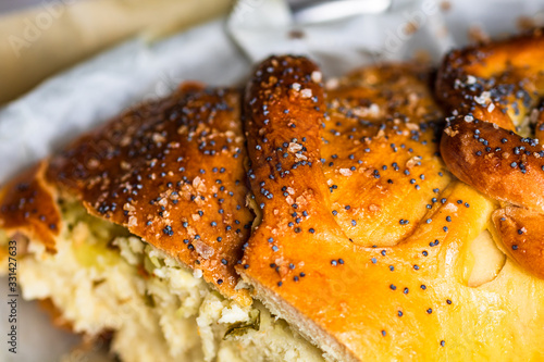 Close up photo with selective focus on details of salt and poppy seeds over a braided puff pastry. photo