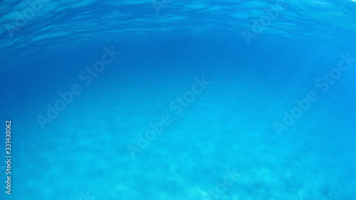 Underwater background photo in clear turquoise blue ocean 